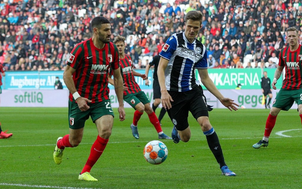 l-r: im Zweikampf, Aktion, mit Daniel Caligiuri 20 FC Augsburg und Fabian Kunze 16 Arminia Bielefeld, FC Augsburg vs. Arminia Bielefeld, 1. Bundesliga, 8. Spieltag, 17.10.2021